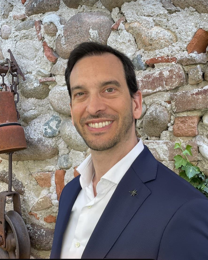 Andrea Padoan, davanti a un muro in sasso della campagna veronese
